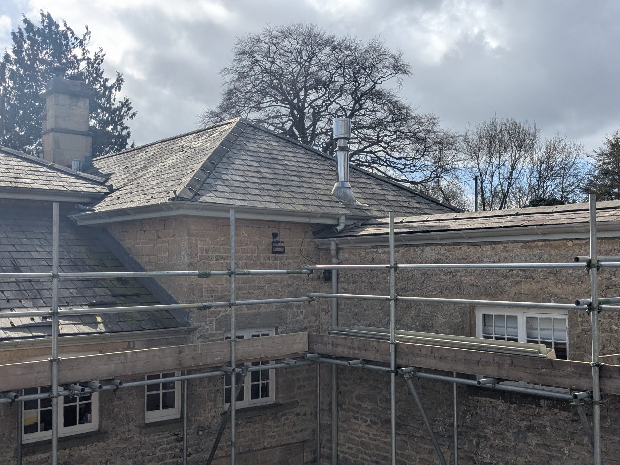 a run of cast iron guttering with corners and downpipes near burford
